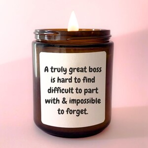 May include: A brown glass candle with a white label that reads "A truly great boss is hard to find difficult to part with & impossible to forget."