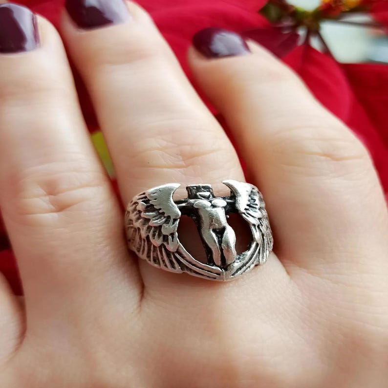Handmade gothic angel ring with wing details and feminine silhouette, shown on finger.