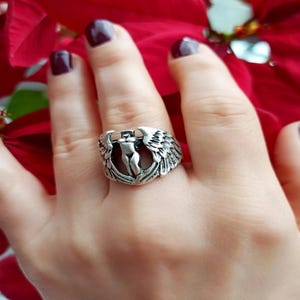 Side angle of silver woman warrior ring with sculpted wings and open band.