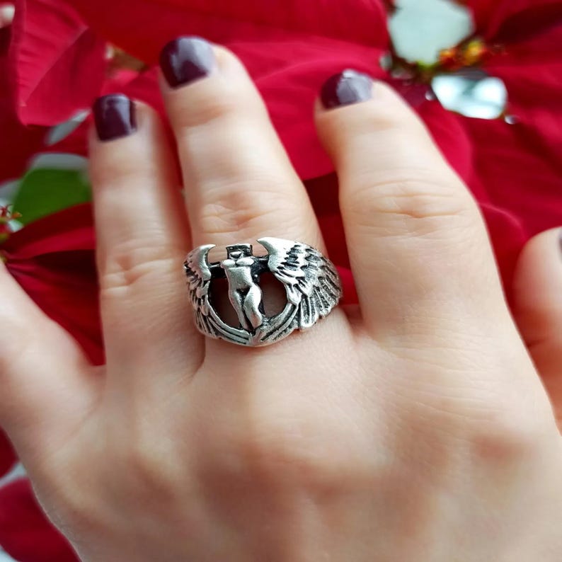 Side angle of silver woman warrior ring with sculpted wings and open band.