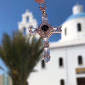 K&ouml;nnte beinhalten: Eine Halskette mit einem Kreuz-Anh&auml;nger aus ros&eacute;gold, besetzt mit klaren Zirkonia-Steinen. Der Anh&auml;nger hat einen runden Mittel-Stein mit einer schwarzen "Ich liebe dich"-Projektion.