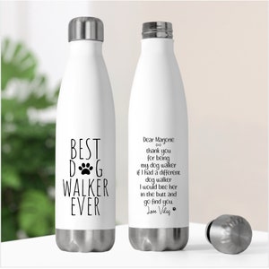 May include: Two white stainless steel water bottles with black text. The bottle on the left says "Best Dog Walker Ever" with a paw print. The bottle on the right says "Dear Marjorie thank you for being my dog walker if I had a different dog walker I would bite her in the butt and go find you Love Vilas".