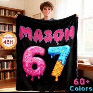 May include: Black blanket with the name "MASON" in pink dripping letters. The number "6" is designed as a pink donut, and the number "7" is designed as a blue ice cream cone. The blanket is made in the USA and ships in 48 hours.
