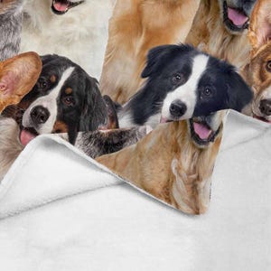 May include: A white fleece blanket with a colorful pattern of various dog breeds. The blanket is folded over, revealing the pattern underneath.