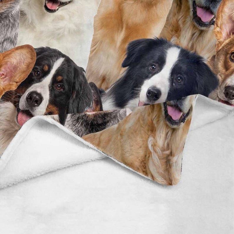 May include: A white fleece blanket with a colorful pattern of various dog breeds. The blanket is folded over, revealing the pattern underneath.