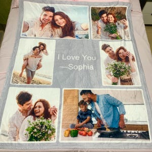 May include: A gray fleece blanket featuring a collage of six photographs of a couple and a family, with the printed text "I Love You &mdash;Sophia" in the center. The images depict various scenes including outdoor portraits, a piggyback ride, and cooking.