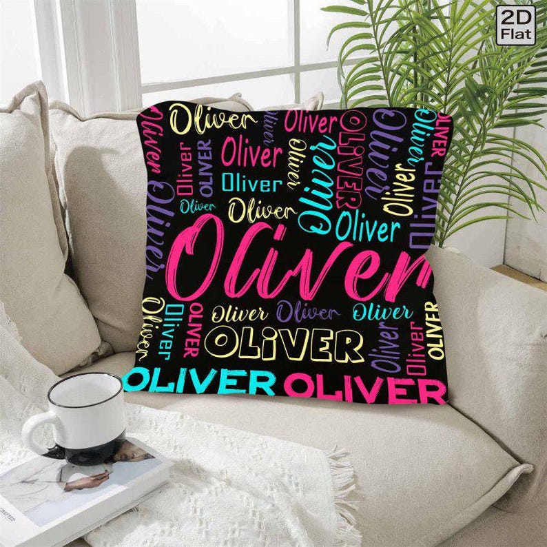 K&ouml;nnte beinhalten: Ein quadratisches Dekokissen mit schwarzem Hintergrund, auf dem der Name Oliver in verschiedenen Schriftarten, Gr&ouml;&szlig;en und Farben wie Pink, Gelb, Hellblau und Lila wiederholt wird. Der Text ist in einem dichten, &uuml;berlappenden Muster angeordnet.