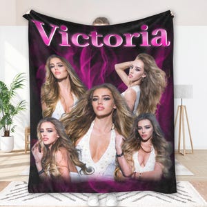 May include: A black blanket featuring multiple images of a woman with long blonde hair and a white dress. The name "Victoria" is displayed in pink, stylized text at the top. The background has a pink, smoky design.