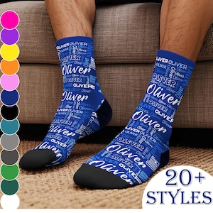 May include: Blue socks with the name "Oliver" in a repeating pattern. The socks have black toes and heels. The image also displays a color palette and the text "20+ STYLES".