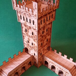 Könnte beinhalten: Ein Holzmodell eines Burgturms mit drei Verbindungsbrücken. Der Turm ist mit Fenstern und einer strukturierten Oberfläche detailliert. Die Brücken haben Bögen und sind auf verschiedenen Ebenen mit dem Turm verbunden.