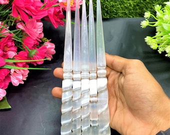 May include: Six white selenite wands with a spiral design. The wands are approximately 10 inches long and have a pointed tip.