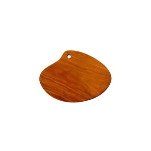May include: A small, irregularly shaped wooden cutting board with a hole in the top. The board is made of light brown wood with a natural grain pattern.