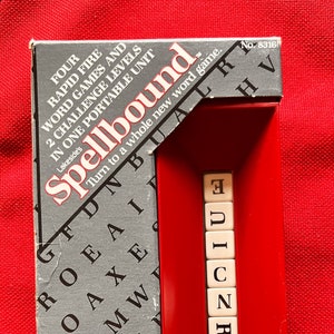 May include: A vintage "Spellbound" word game in its original packaging. The box is gray and red, with the game title prominently displayed. The game includes lettered tiles to spell words. The box reads "for 2 to 4 players ages 8 to adult."