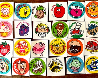 May include: A set of 20 colorful round stickers with various cartoon characters and phrases. The stickers feature themes like food, animals, and fun activities. Some of the phrases include "Poppin' Good", "Grape Going", "Snappy", "Wild", "Super Stuff", "Keep Rolling", "Bee-Utiful", and "Minty Good".