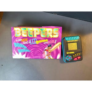 May include: A pink and purple box with the text "Beepers" and "A hip new kind of LCD game and more!"  A blue and green handheld game with the text "Beepers" and "MVP Baseball" is shown.