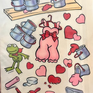 May include: A set of stickers featuring a frog wearing a cape, paint cans, paint rollers, paint brushes, hearts, and a pink dress with a bow. The stickers are from Jim Henson Productions, Inc.