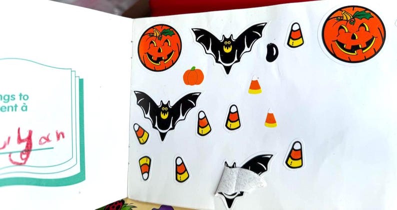May include: A collection of Halloween-themed stickers featuring jack-o'-lanterns, bats, and candy corn. The stickers are in various sizes and are primarily orange, black, and yellow. The stickers are on a white background.