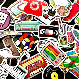 May include: A collection of colorful stickers featuring retro 80s and 90s icons, including a cassette tape, a Rubik's Cube, a boombox, a rotary phone, a video cassette, a television, a pair of sunglasses, a roller skate, a keyboard, and a record player.