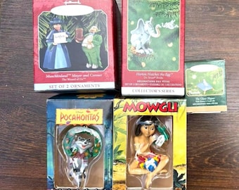Op de afbeelding: Een verzameling Hallmark kerstversieringen, elk in de originele doos. De ornamenten beelden personages uit verhalen uit, zoals "The Wizard of Oz", "Horton Hatcher the Egg", "Pocahontas" en "Mowgli". Verzamelaarsreeks.