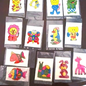 May include: A collection of colorful temporary tattoos featuring various cartoon animals, including a cow, cat, frog, lion, butterfly, penguin, elephant, fish, snail, rabbit, and giraffe. Each tattoo is individually packaged.