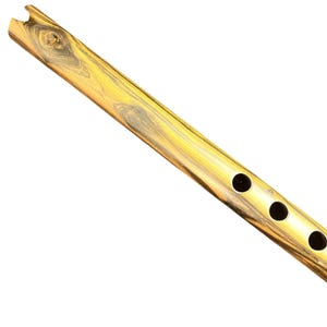 May include: A wooden flute featuring a polished finish with prominent golden and dark brown swirling wood grain patterns. The instrument has a notched mouthpiece at the top end and three circular finger holes aligned along the side of the body.