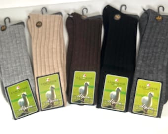 May include: Five pairs of alpaca wool socks in different colors: gray, beige, brown, black, and dark gray. Each pair has a green tag with the word "Lancaster" and an image of an alpaca.