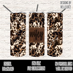 Puede incluir: Un diseño de sublimación para un vaso con un estampado de leopardo marrón y blanco con un parche de cuero marrón que dice "wifey".