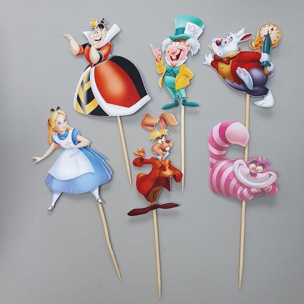 Peut inclure: Six décorations de gâteau sur le thème d'Alice au pays des merveilles. Les décorations représentent Alice, le Chapelier Fou, la Reine de Cœur, le Chat du Cheshire, le Lapin Blanc et le Lièvre de Mars. Les décorations sont imprimées sur du papier cartonné et fixées à des brochettes en bois.