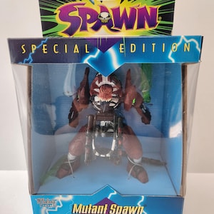 May include: A boxed Mutant Spawn Ultra-Action Figure. The figure is primarily brown and black, with green accents. The packaging includes the text "Todd McFarlane's Spawn" and "Special Edition". The box is clear plastic, showcasing the action figure.