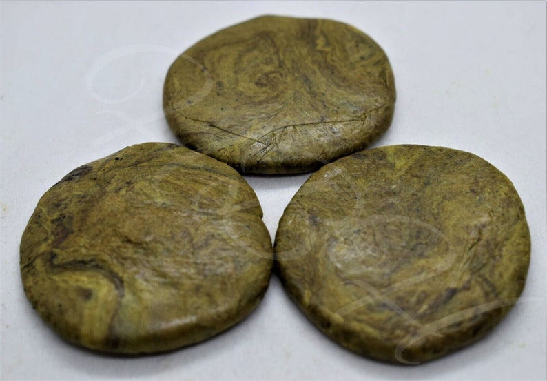 May include: Three round, green and brown, marbled coasters. The coasters are made of a natural material and have a rough texture.