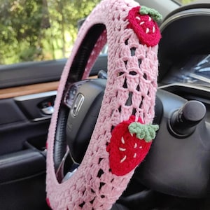 May include: Pink crocheted steering wheel cover with red and green strawberry appliques.