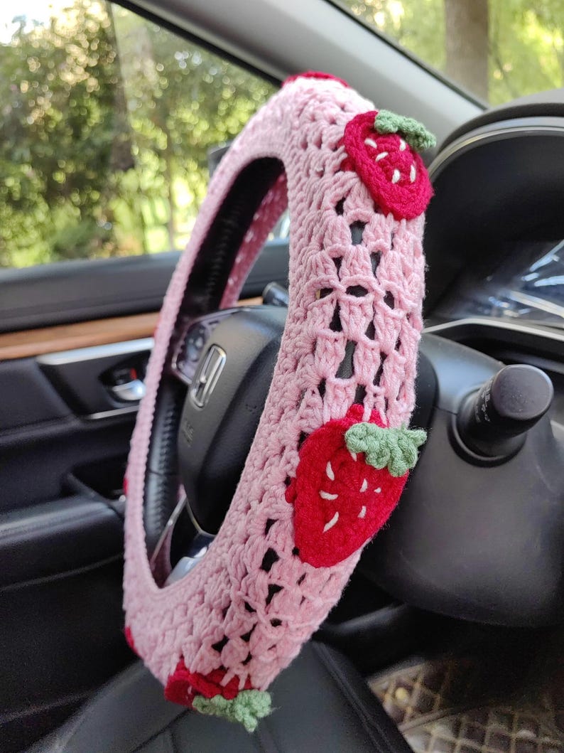 May include: Pink crocheted steering wheel cover with red and green strawberry appliques.