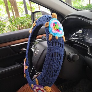 May include: Blue crocheted steering wheel cover with colorful crocheted turtle embellishments.