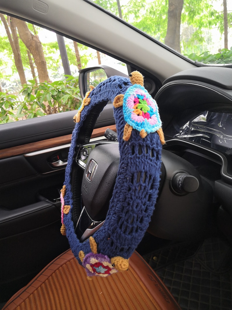 May include: Blue crocheted steering wheel cover with colorful crocheted turtle embellishments.
