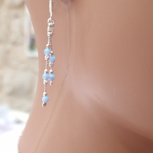 May include: Silver dangle earrings with light blue opal beads.