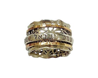 May include: A stack of silver rings with gold accents. The rings have intricate openwork designs and Hebrew text. The rings are stacked together, creating a layered effect. The rings are made of sterling silver and gold.