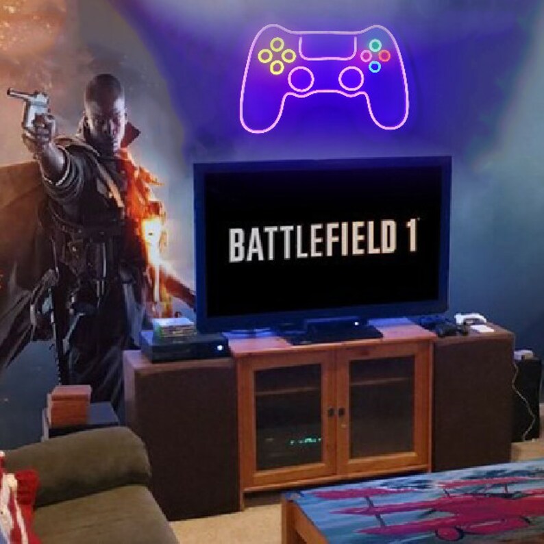May include: A television screen displaying the text "BATTLEFIELD 1" with a neon purple and blue video game controller on the wall behind it.