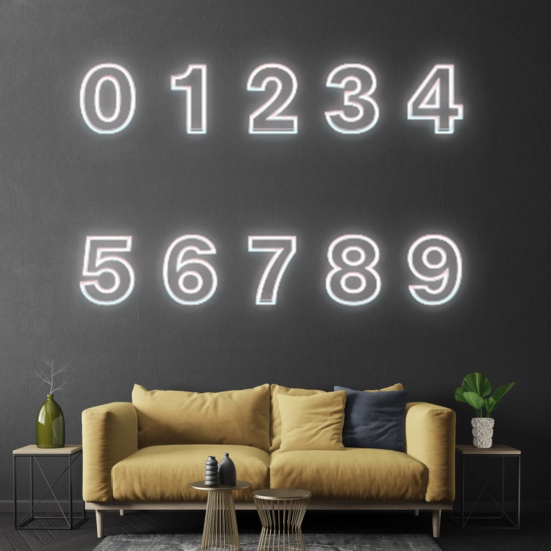 Pu&ograve; includere: Numeri bianchi al neon da 0 a 9 su una parete grigio scuro. I numeri sono contornati di bianco e hanno un bagliore rosa. Un divano giallo con un cuscino blu &egrave; in primo piano.