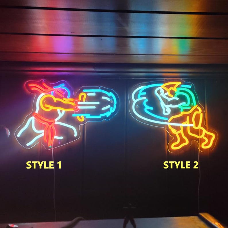 May include: Two neon signs featuring video game character silhouettes. Style 1 shows a figure in red and blue emitting a projectile. Style 2 shows a figure in yellow and blue performing a spinning kick. Both signs are mounted on a dark wall.