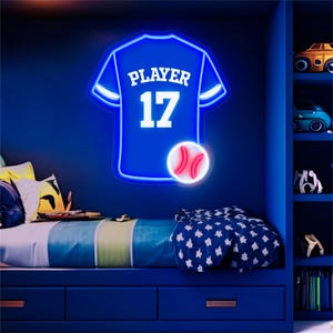 Pode incluir: Um letreiro de néon azul em forma de camisola de basebol com a palavra PLAYER e o número 17 em branco, acompanhado por um ícone de basebol de néon branco e vermelho. O letreiro apresenta contornos de luz azul brilhante e design moderno.