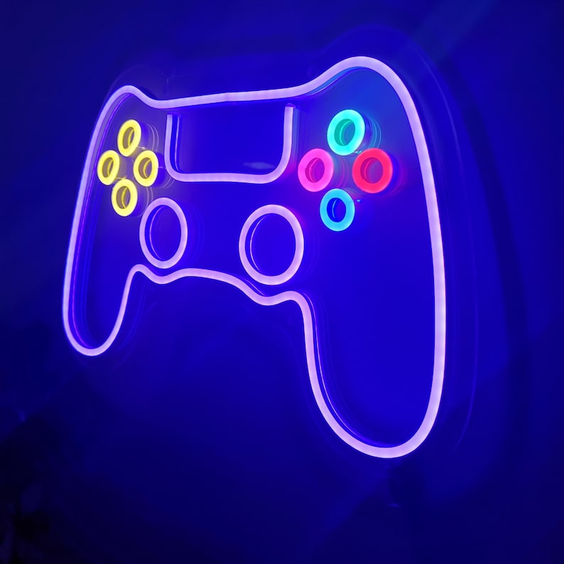 May include: A neon sign shaped like a video game controller with purple, yellow, pink, and blue lights.