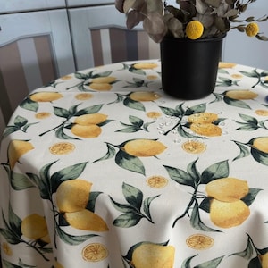 Water-repellent tablecloth with lemons on a milky background. Table setting. Water-repellent effect retains spilled liquids on the surface.