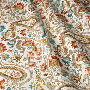 May include: White fabric with a paisley pattern in shades of brown, orange, and teal.