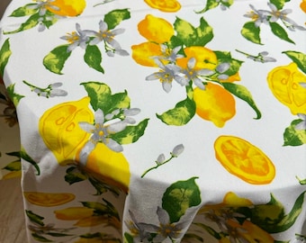 Water-repellent tablecloth with lemons and green leaves. Table setting. Water-repellent effect retains spilled liquids on the surface.