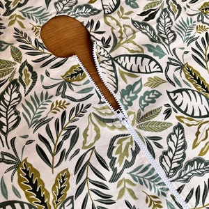 Nappe avec trou pour parasol. Nappe d'extérieur imperméable avec des feuilles et des plantes. Le téflon retient les liquides renversés à la surface