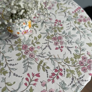 Water-repellent tablecloth with floral and plant print. Cottagecore decor. Table setting.This effect retains spilled liquids on the surface.