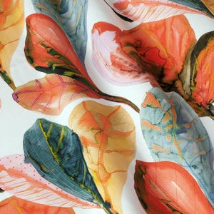 May include: A white fabric with a watercolor pattern of overlapping leaves in shades of orange, red, green, and yellow.