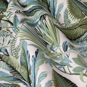 Może przedstawiać: Biała tkanina z tropikalnym wzorem liści w odcieniach zieleni i błękitu. Tkanina ma subtelną fakturę i miękki, płynny drapaż.