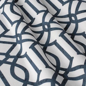 May include: White fabric with a navy blue geometric pattern. The pattern is made up of repeating circles and lines.