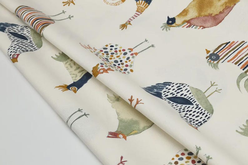 May include: White fabric with a repeating pattern of colorful chickens. The chickens are illustrated in a whimsical style with various colors and patterns.